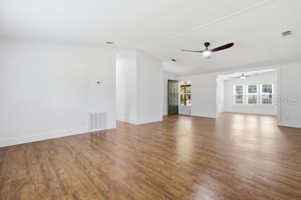 An open-concept living area features wood-look flooring, white walls, and two ceiling fans — 24225 DUFFIELD ROAD, BROOKSVILLE, FL