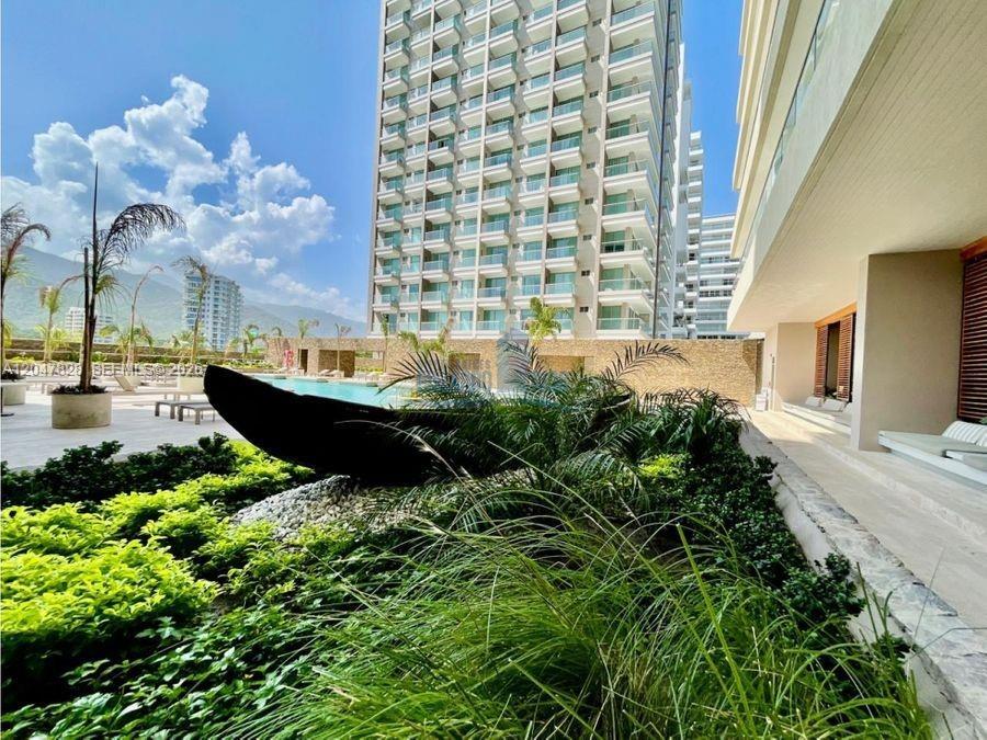 A modern high-rise building overlooks a swimming pool and a landscaped patio area — 114 Cra. 2 #114-03 # 121, FL