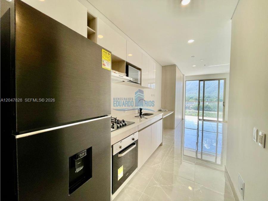 A modern kitchen features white cabinetry, stainless steel appliances, and a view of mountains outside — 114 Cra. 2 #114-03 # 121, FL
