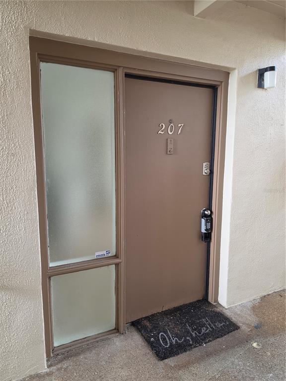 A brown apartment door numbered 207 features a keypad lock and a frosted glass sidelight — 618 ORANGE DRIVE UNIT 207, ALTAMONTE SPRINGS, FL
