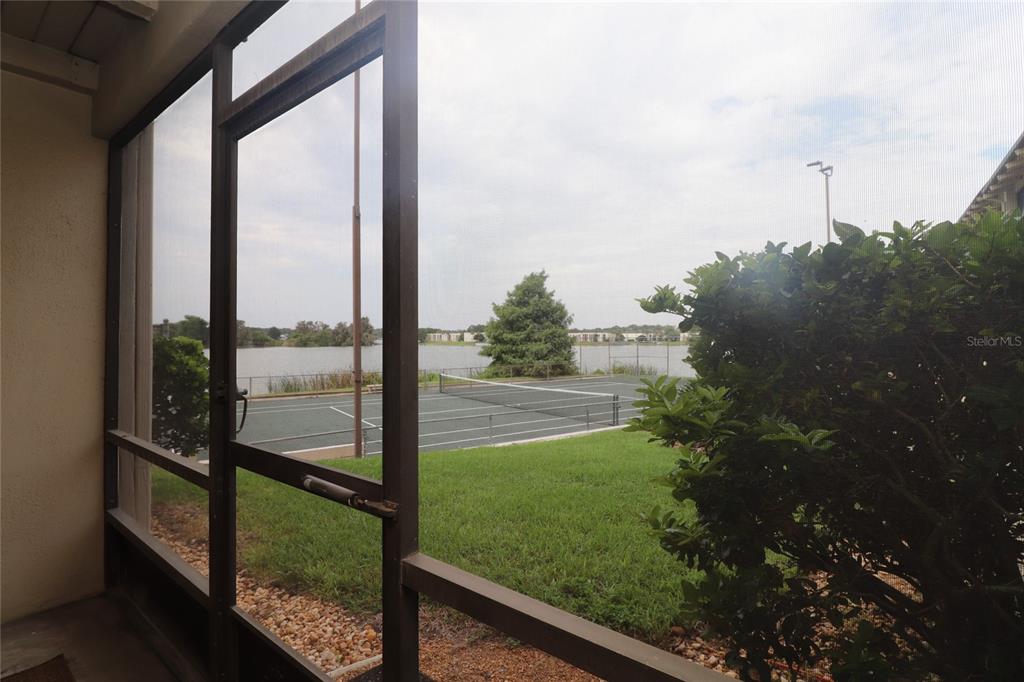 A screened-in porch overlooks a tennis court and a lake — 618 ORANGE DRIVE UNIT 207, ALTAMONTE SPRINGS, FL