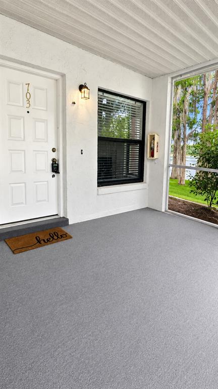 The entrance to Northlake Village features a stone sign, palm trees, and a paved driveway — 703 NORTHLAKE DRIVE UNIT 703, SANFORD, FL