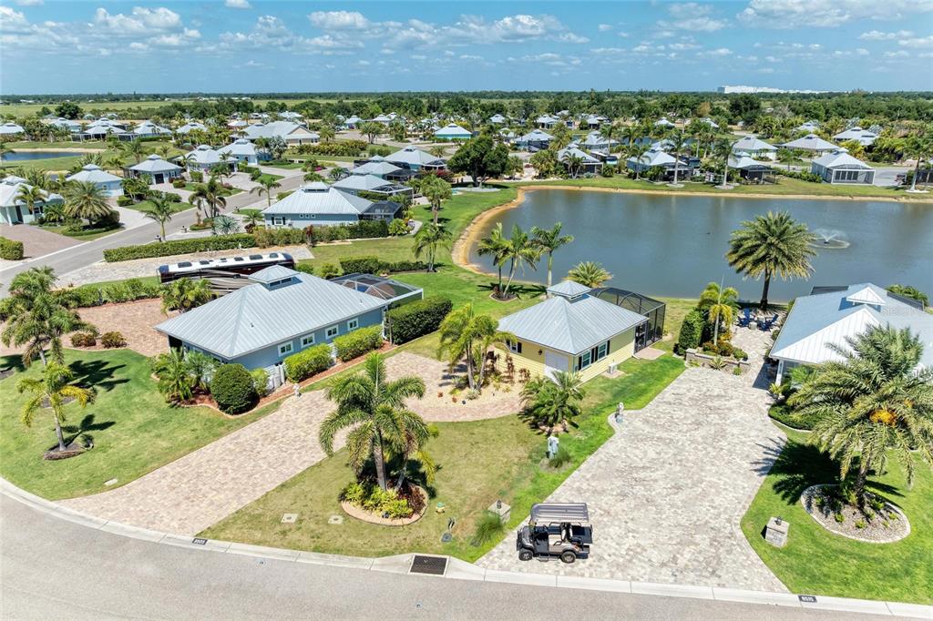 An aerial view of three houses with paved driveways and palm trees near a lake — 8503 SW SAND CRANE CIRCLE LOT 74, ARCADIA, FL