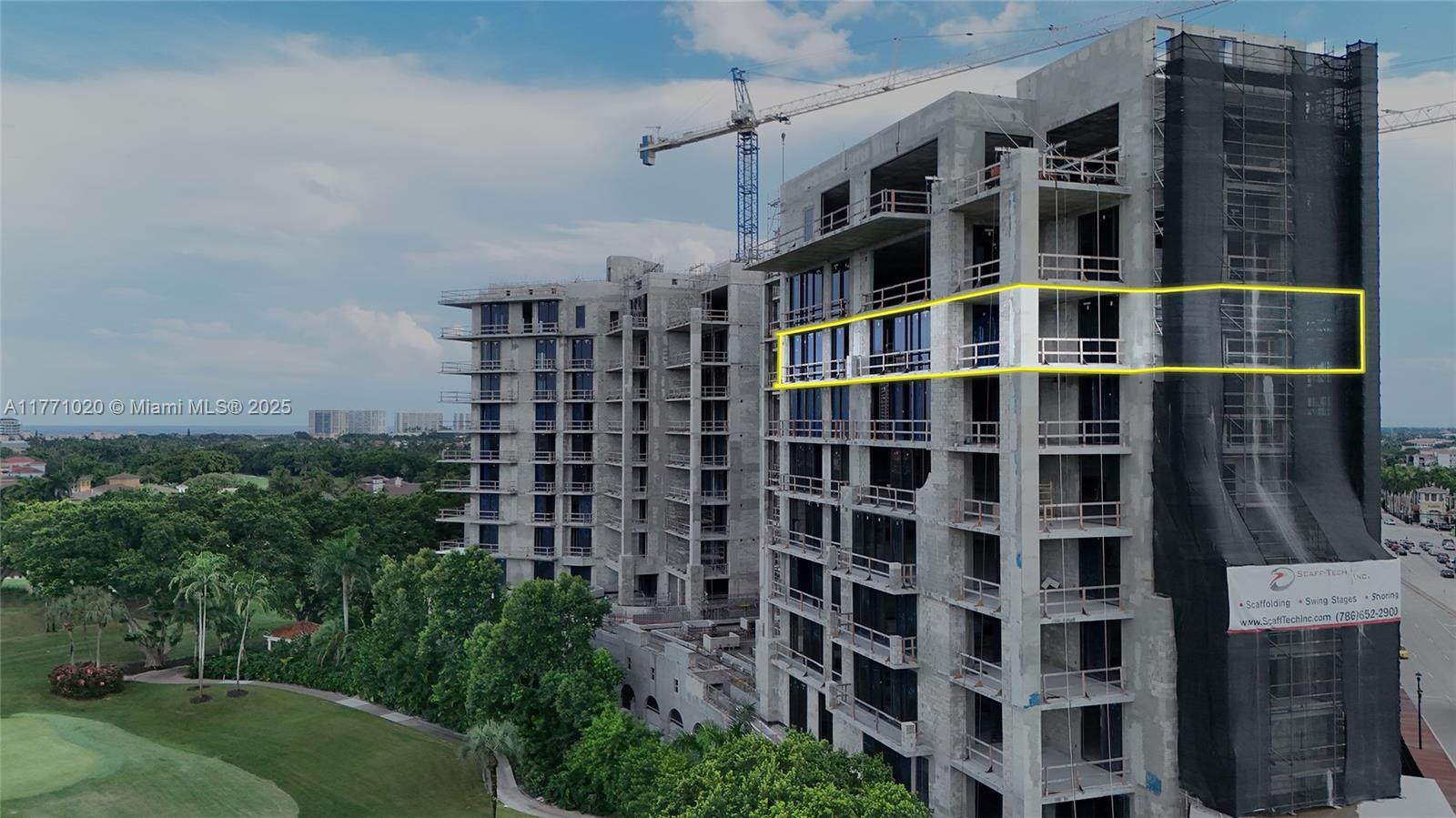 An exterior view of a multi-story concrete building under construction with scaffolding and glass windows — 105 E Camino Real # 912, Boca Raton FL 33432, BOCA RATON, FL