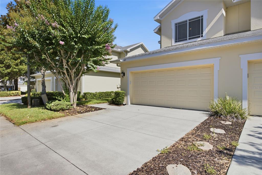 A two-story house with a beige exterior, a two-car garage, and a concrete driveway — 485 HARBOR RIDGE DRIVE, PALM HARBOR, FL