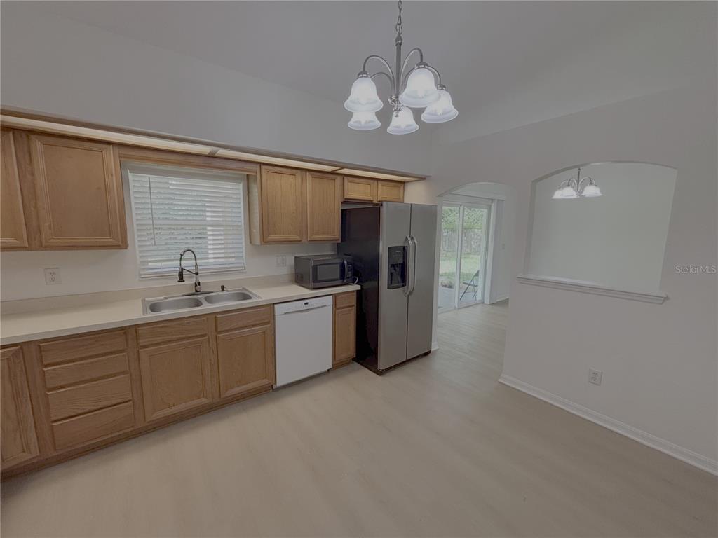 A kitchen features light wood cabinets, stainless steel appliances, and a white dishwasher — 10417 SW 52ND COURT, OCALA, FL
