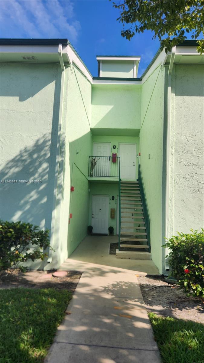 A two-story light green apartment building exterior features an outdoor staircase leading to upper units — 4086 N Pine Island Rd # 510, Sunrise FL 33351, SUNRISE, FL
