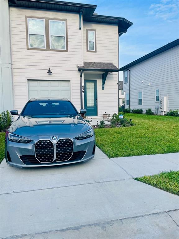 A gray BMW is parked in the driveway of a two-story house with light siding — 1039 PLANTATION LANE, DAVENPORT, FL