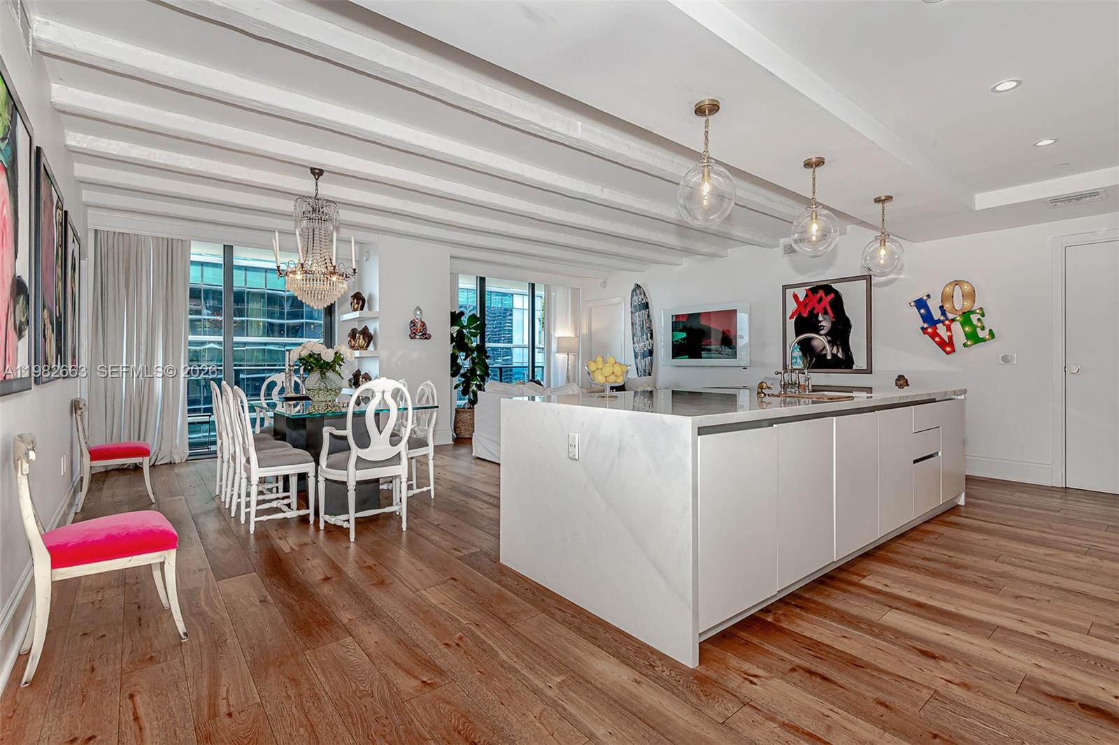 A modern kitchen and dining area features white cabinetry, a marble island, and wood flooring — 801 S Miami Ave # 4508, Miami FL 33130, MIAMI, FL