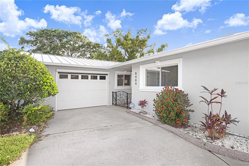 A single-story house exterior features a white garage door, gray siding, and a concrete driveway — 8404 BLACKSTONE COURT, TAMPA, FL