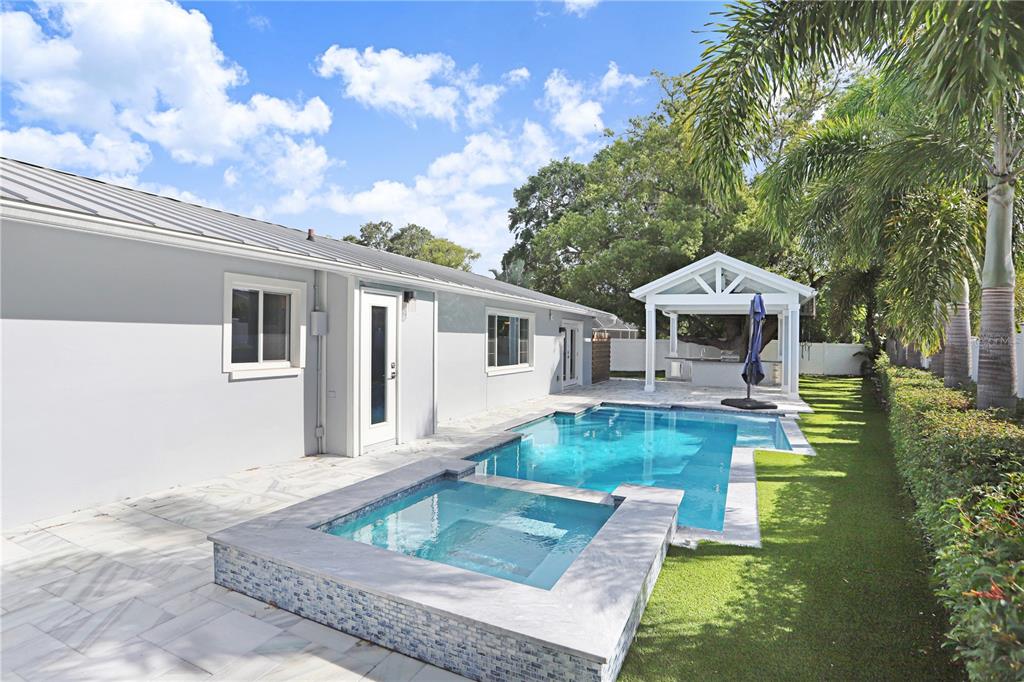 A backyard features a swimming pool, a raised spa, a patio, and a covered pavilion — 8404 BLACKSTONE COURT, TAMPA, FL