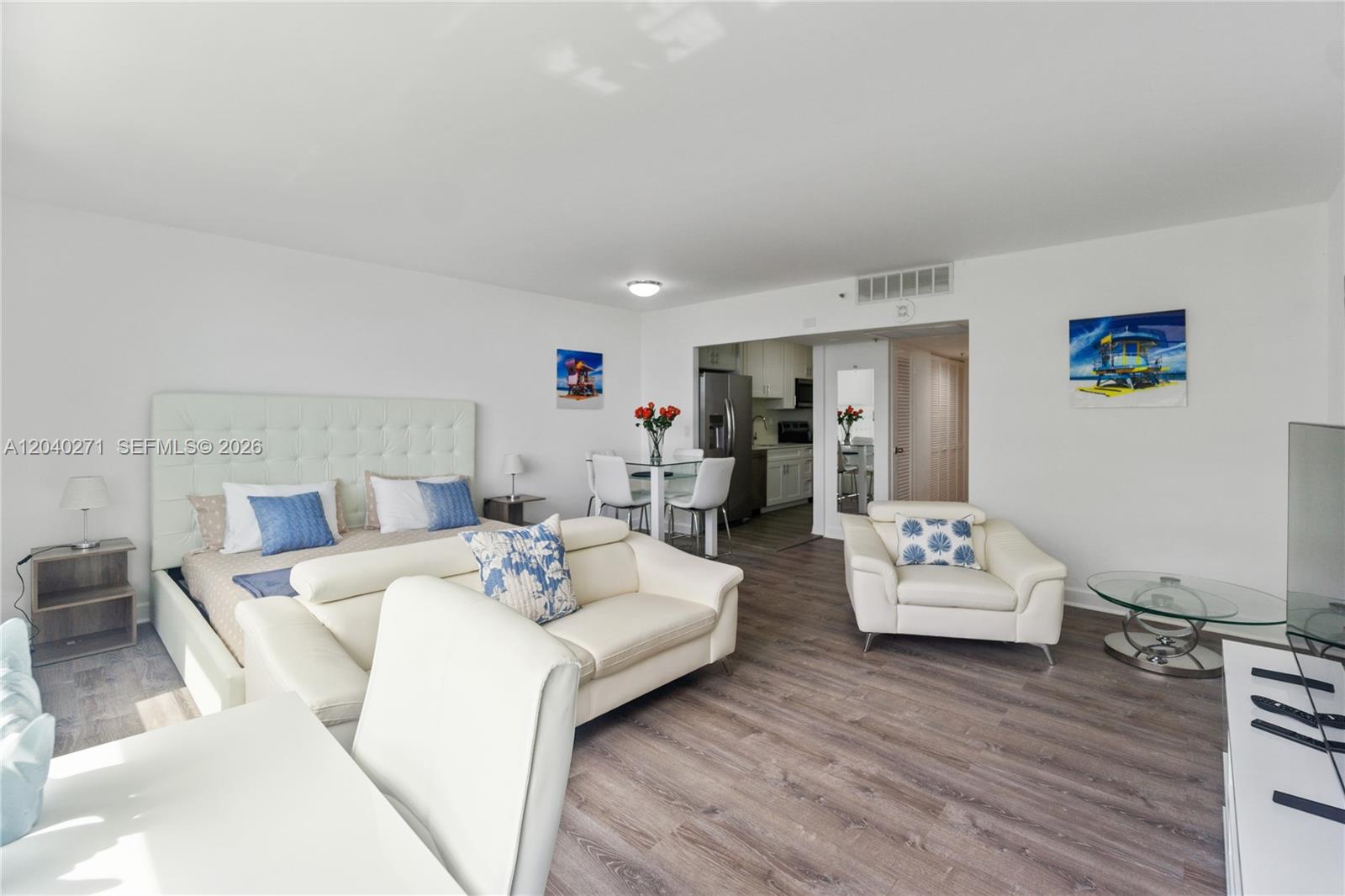 A studio apartment features a bed, a white sofa, a dining set, and wood-look flooring — 100 Lincoln Rd # 538, Miami Beach FL 33139, MIAMI BEACH, FL