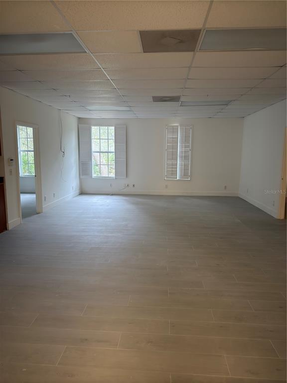 An empty office space with light-colored tile flooring, a drop ceiling, and two windows — 17880 TOLEDO BLADE BOULEVARD, PORT CHARLOTTE, FL