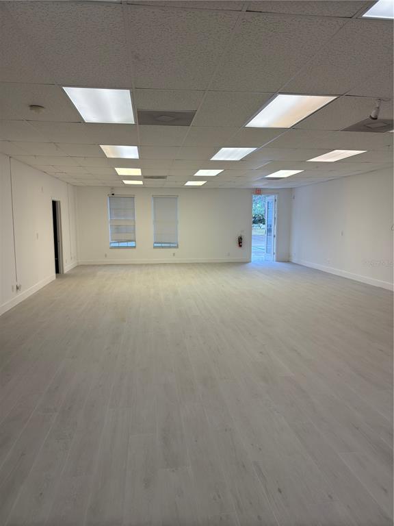 An empty commercial office space features light-colored wood-look flooring, white walls, and a drop ceiling — 17880 TOLEDO BLADE BOULEVARD, PORT CHARLOTTE, FL
