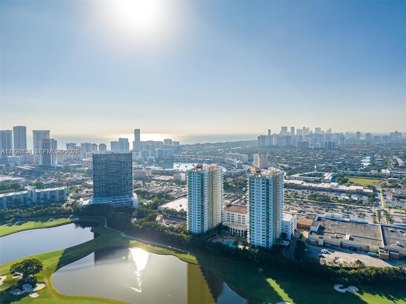 An aerial view shows high-rise residential buildings overlooking a golf course and a coastal city — 1745 E Hallandale Beach Blvd # 2304W, Hallandale Beach FL 33009, HALLANDALE BEACH, FL