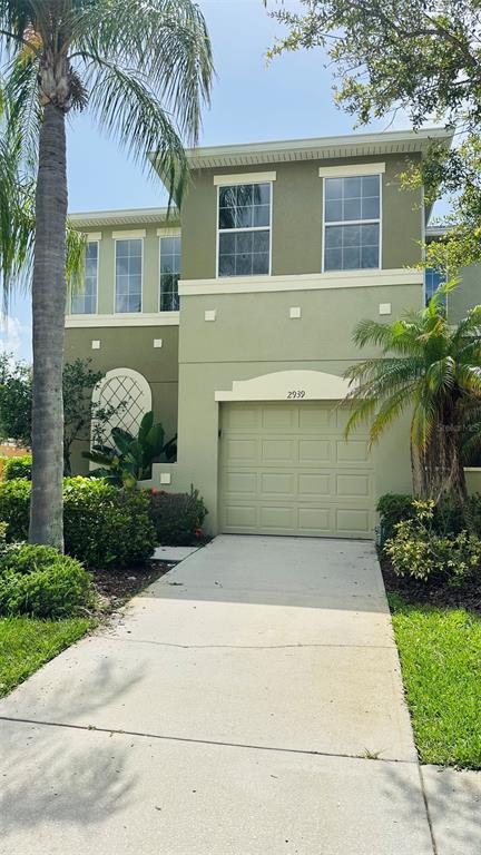 A two-story house with a light green exterior, a single-car garage, and a palm tree — 2939 WILLOWLEAF LANE, WESLEY CHAPEL, FL