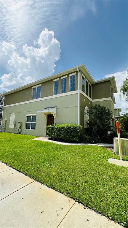 A two-story, light green residential building with a small front porch and manicured lawn — 2939 WILLOWLEAF LANE, WESLEY CHAPEL, FL