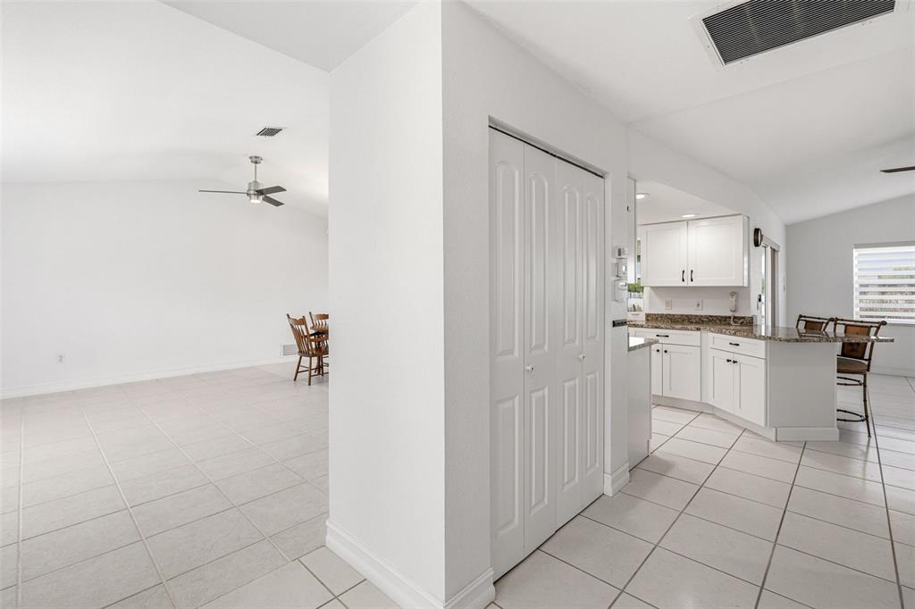 A white-walled interior features a tiled floor, a kitchen with white cabinets, and a closet — 15184 ALDAMA CIRCLE, PORT CHARLOTTE, FL