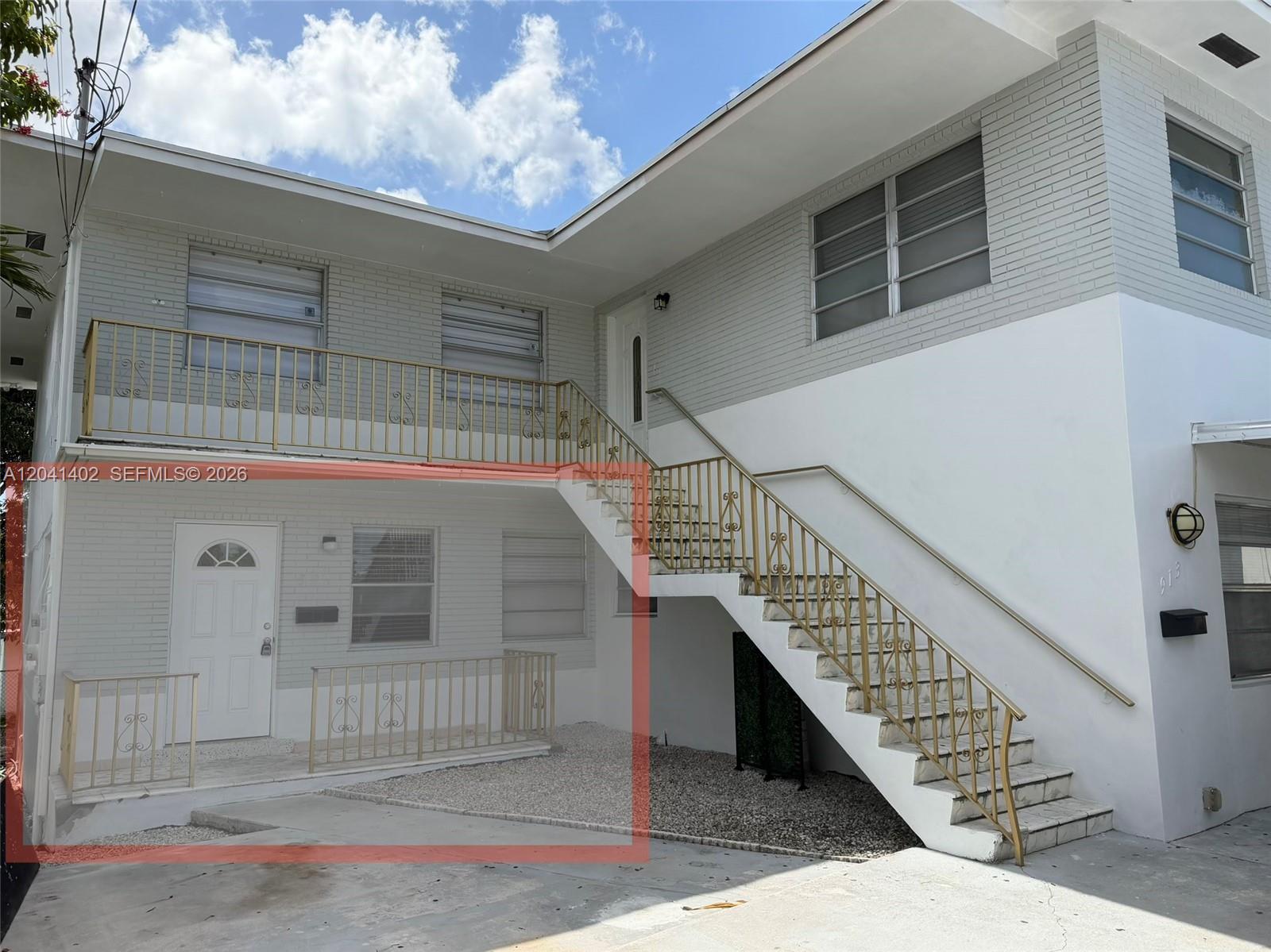 The exterior of a two-story building features white brick, a metal staircase, and gravel landscaping — 911 NW 22nd Pl # 0, Miami FL 33125, MIAMI, FL