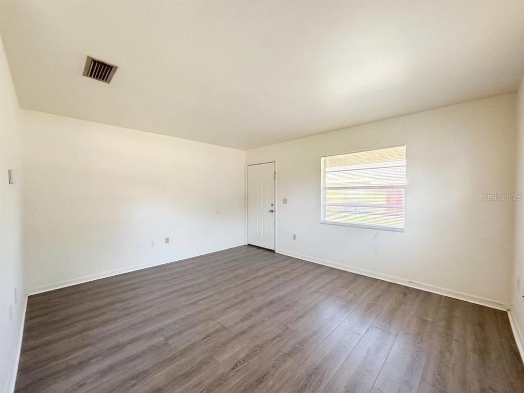 An empty room with white walls, a window with blinds, and wood-look flooring — 1240 JOSEPHINE STREET, LAKELAND, FL