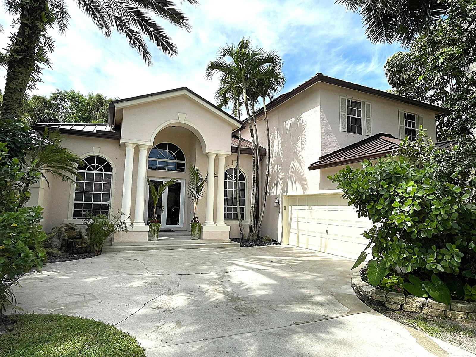 A two-story house with a columned entryway, arched windows, and a concrete driveway — 4740 Glenn Pine Lane, Boynton Beach FL 33436, BOYNTON BEACH, FL