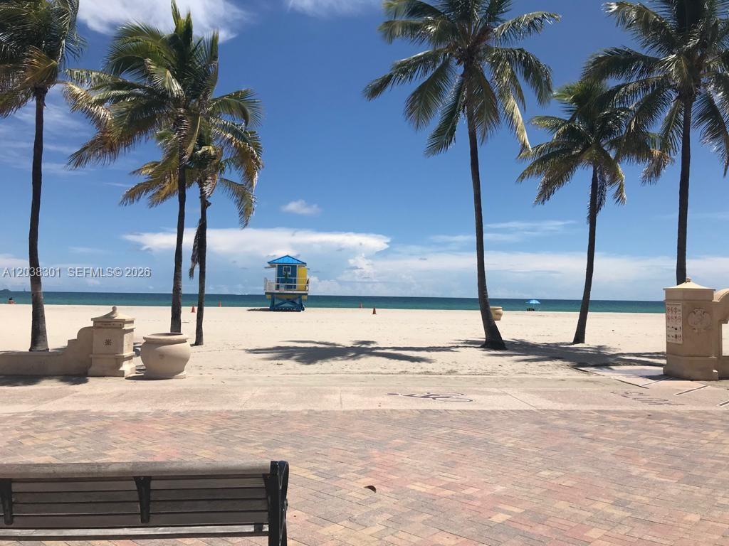A view of a sandy beach with palm trees and a lifeguard tower — 320 S Surf Rd # 305, Hollywood FL 33019, HOLLYWOOD, FL