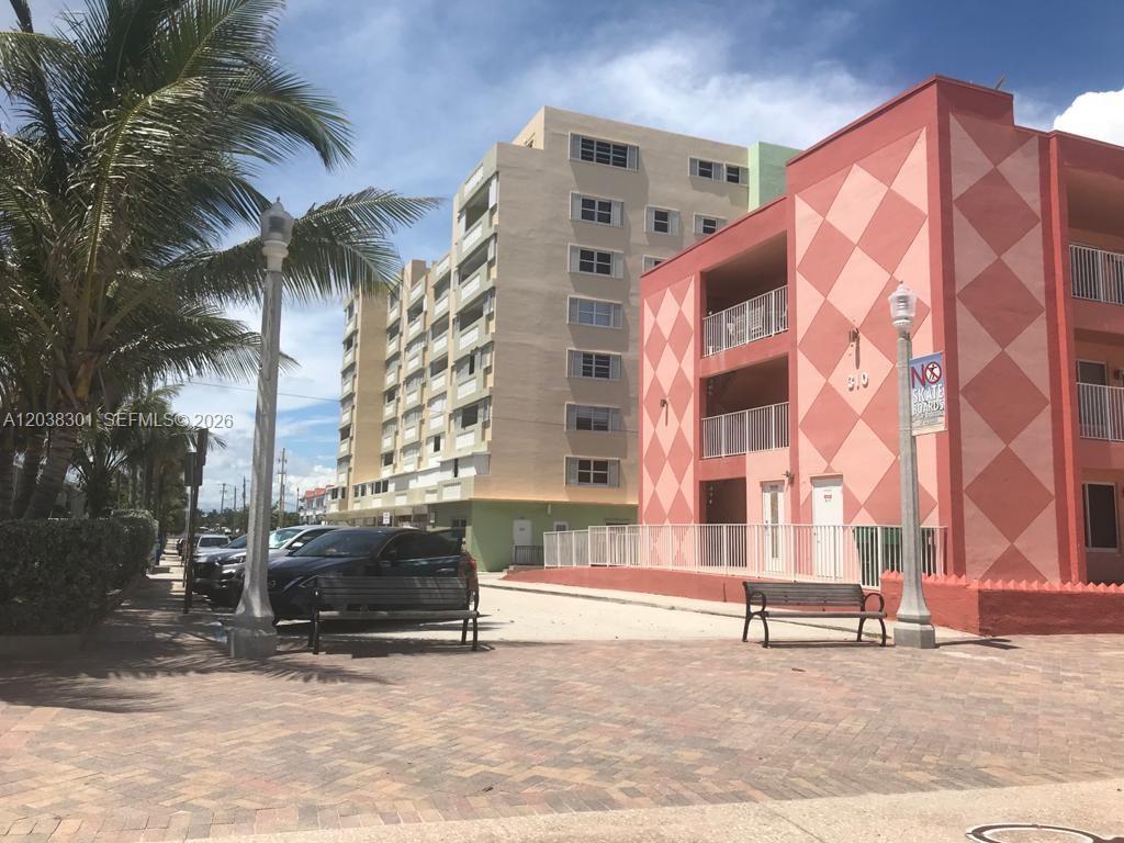An exterior view of a multi-story apartment building with a pink diamond-patterned facade — 320 S Surf Rd # 305, Hollywood FL 33019, HOLLYWOOD, FL