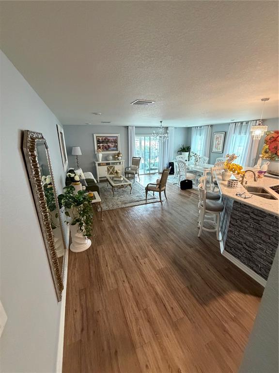 An open-concept living and dining area features wood-look flooring and a kitchen island — 3024 FIELDWOOD CIRCLE, ST CLOUD, FL