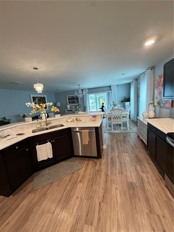 A kitchen with dark cabinets and light countertops overlooks a dining area and living room — 3024 FIELDWOOD CIRCLE, ST CLOUD, FL