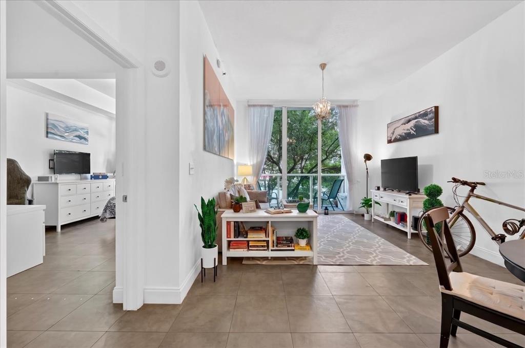 A living room with tile floors, a coffee table, a television, and a balcony view — 31 SE 5TH STREET UNIT 203, MIAMI, FL