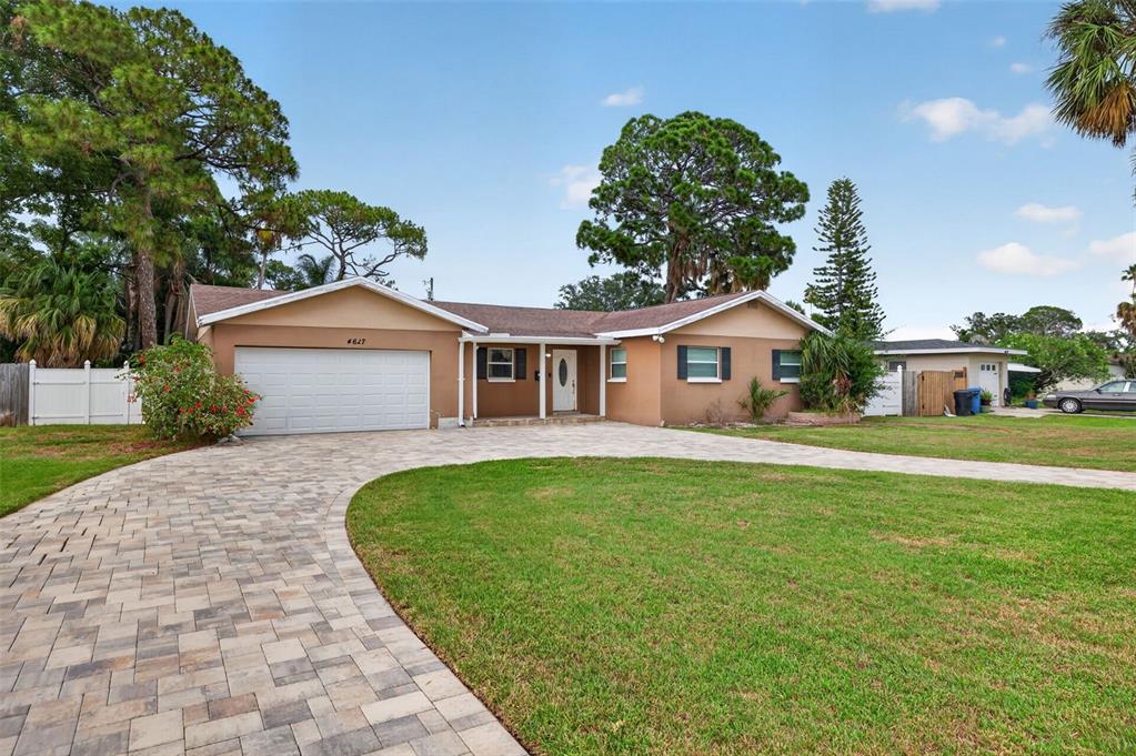 A single-story house with a paved driveway, a two-car garage, and a large front lawn — 4627 VENETIAN BOULEVARD NE, ST PETERSBURG, FL
