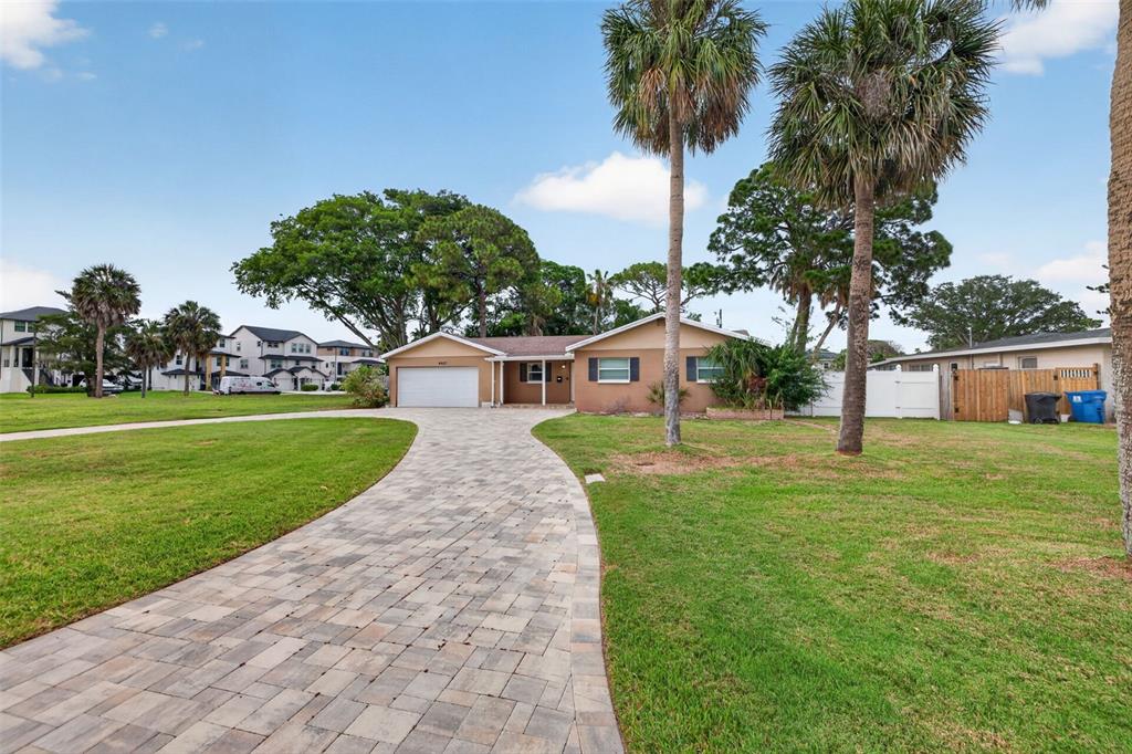 A single-story house with a paved driveway, palm trees, and a large front lawn — 4627 VENETIAN BOULEVARD NE, ST PETERSBURG, FL