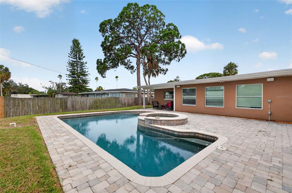 A backyard features a rectangular swimming pool with an attached spa and paver patio — 4627 VENETIAN BOULEVARD NE, ST PETERSBURG, FL