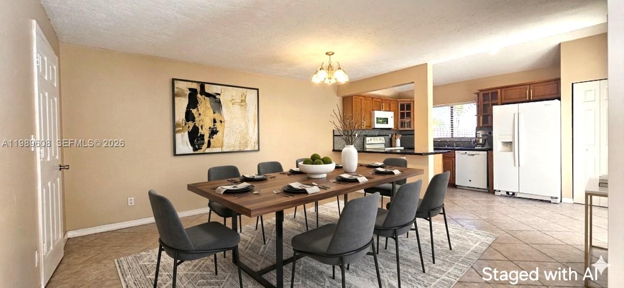 A dining area with a wooden table and gray chairs sits adjacent to a kitchen — 610 Commodore Dr, Plantation FL 33325, PLANTATION, FL