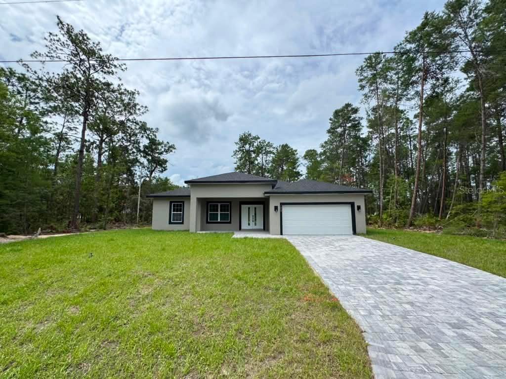 A single-story house with a gray exterior, a two-car garage, and a paved driveway — 1458 W LANDMARK DRIVE, CITRUS SPRINGS, FL