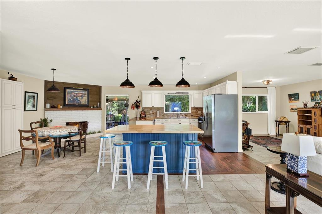 A kitchen features a blue island with bar stools, white cabinetry, and tile flooring — 4064 N CONCORD DRIVE, CRYSTAL RIVER, FL