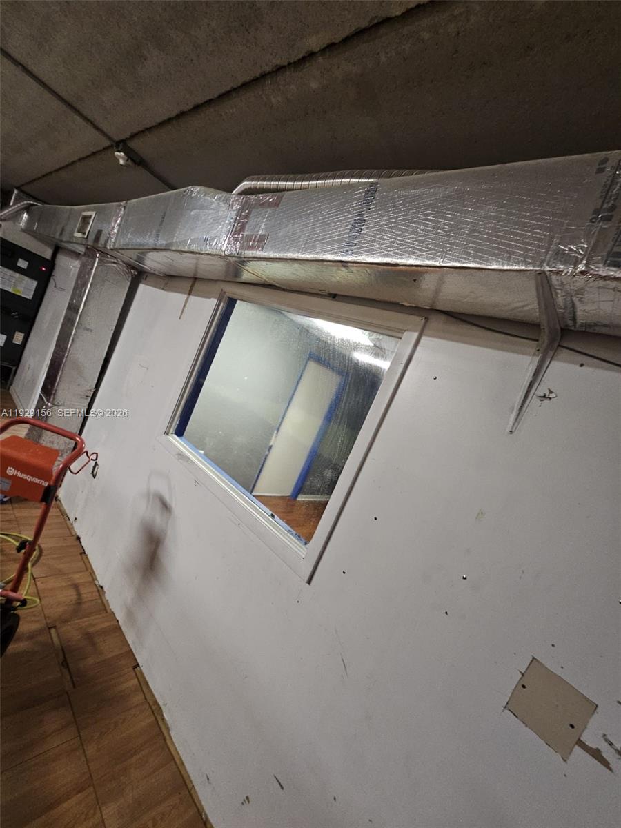 A room features a large rectangular window, exposed ceiling, and a prominent silver HVAC duct — 6175 NW 167th St # G18, Hialeah FL 33015, HIALEAH, FL