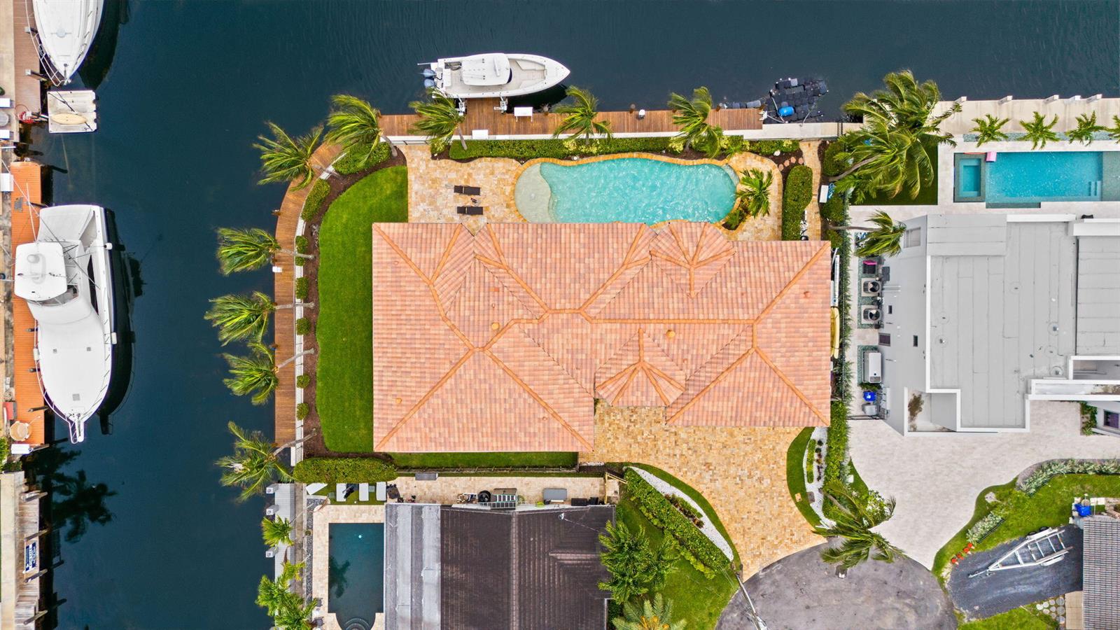 An aerial view shows a waterfront house with a tiled roof, pool, and docked boats — 1261 NE 27th Way, Pompano Beach FL 33062, POMPANO BEACH, FL