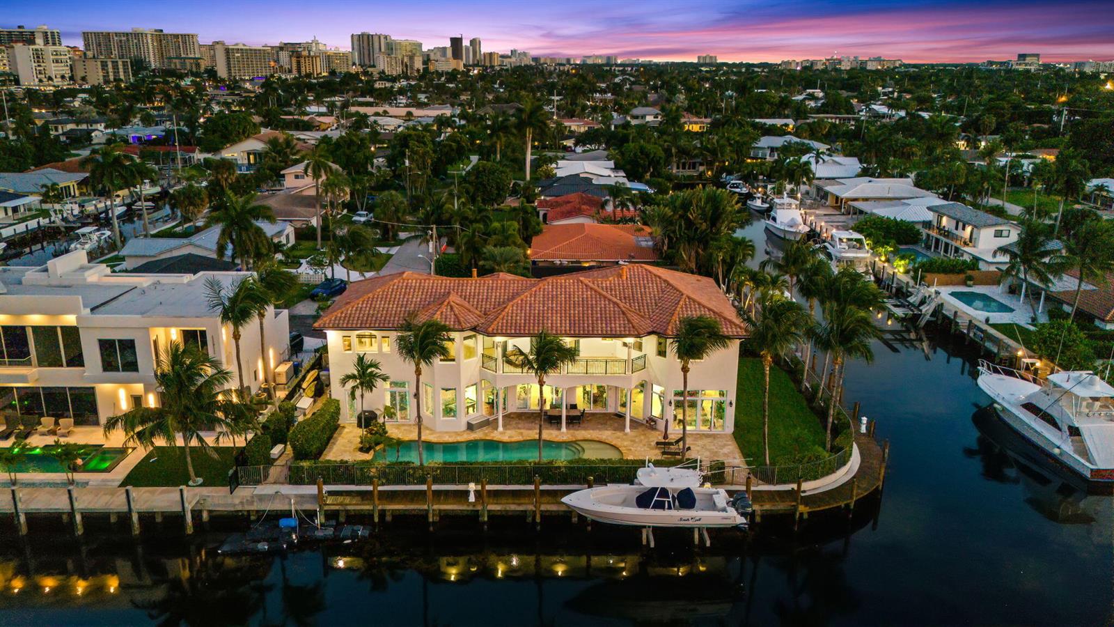 An aerial view of a waterfront house with a tiled roof, pool, and private dock — 1261 NE 27th Way, Pompano Beach FL 33062, POMPANO BEACH, FL