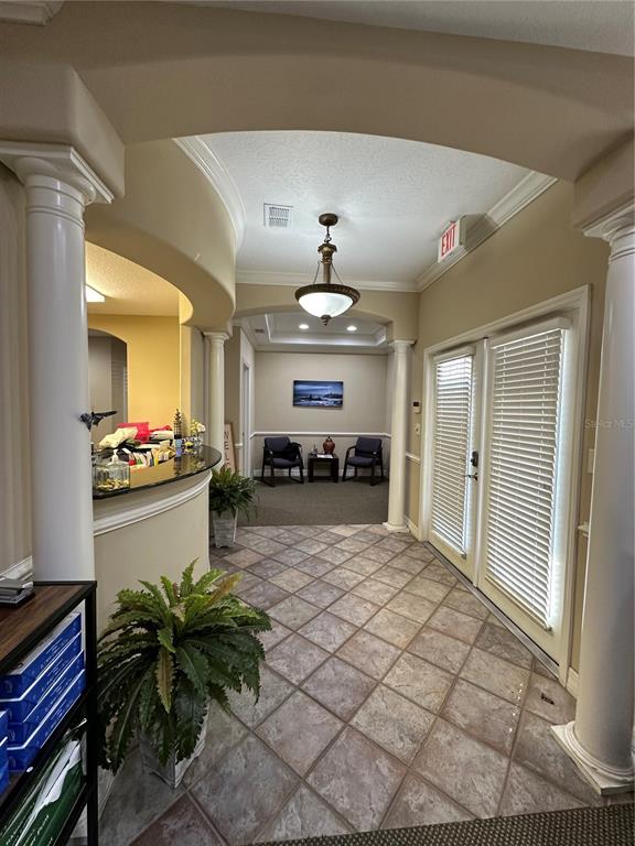 A reception area features a curved desk, tiled floors, columns, and a seating area — 8345 GUNN HIGHWAY, TAMPA, FL