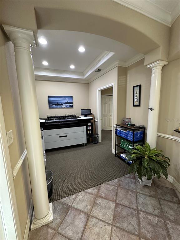 An office space features a large printer, a shelving unit, and columns framing the entrance — 8345 GUNN HIGHWAY, TAMPA, FL