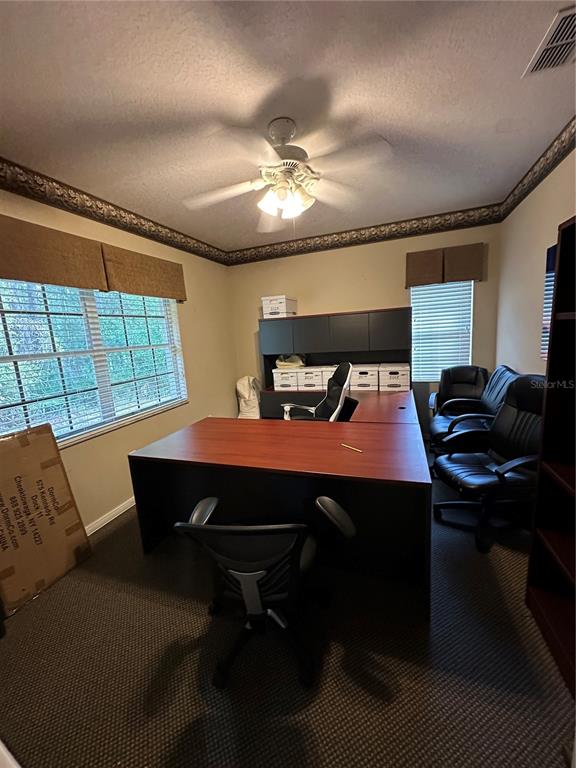 A home office features a large L-shaped desk, several chairs, and a ceiling fan — 8345 GUNN HIGHWAY, TAMPA, FL