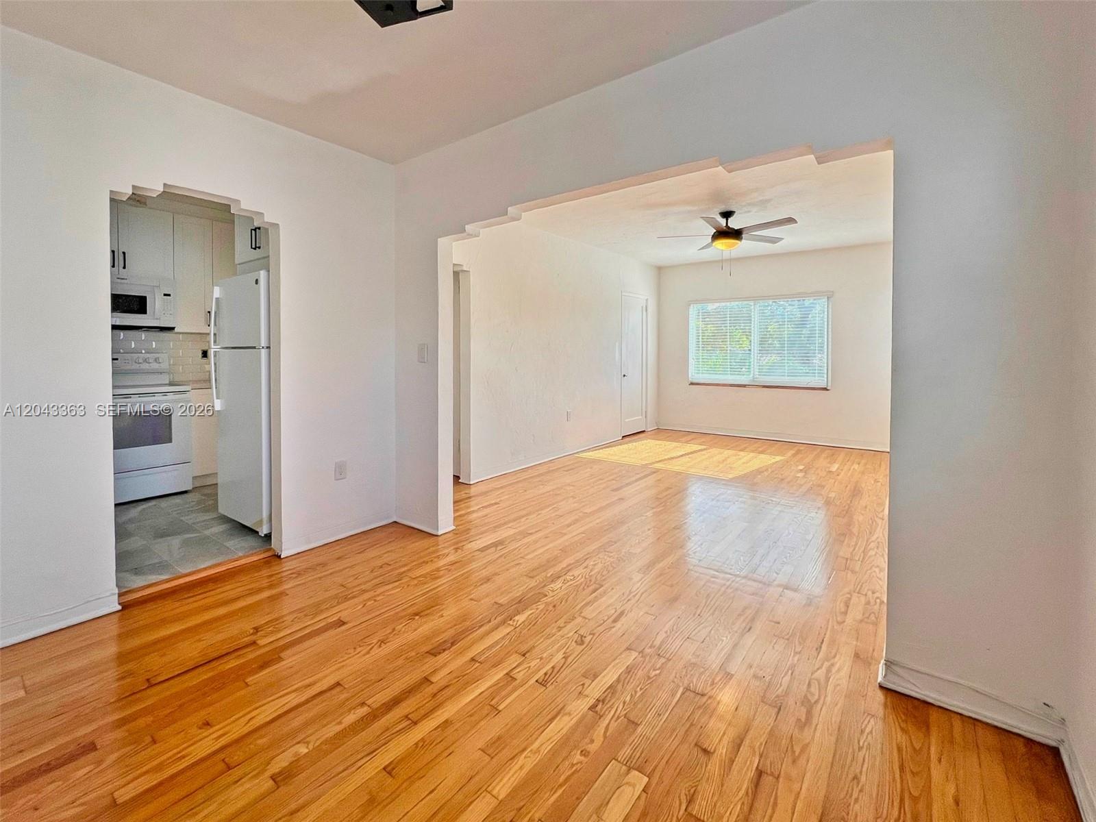A view from a hardwood-floored room looking into a kitchen and a living area — 2102 SW 14 Ter # 1466, Miami FL 33145, MIAMI, FL