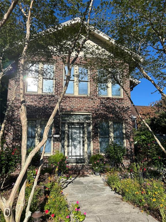 A two-story brick house with a front walkway and landscaping under a clear blue sky — 5205 N CENTRAL AVENUE, TAMPA, FL