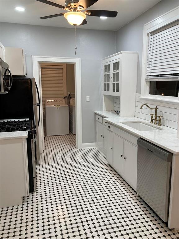 A kitchen features white cabinets, marble countertops, a subway tile backsplash, and black-and-white tiled flooring — 5205 N CENTRAL AVENUE, TAMPA, FL