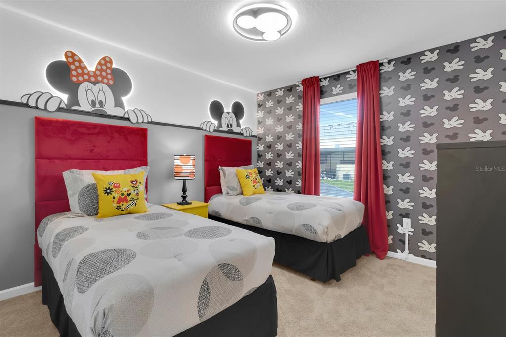 A bedroom features two twin beds with Mickey and Minnie Mouse themed decor and wallpaper — 2312 ZABALLINA PLACE, KISSIMMEE, FL