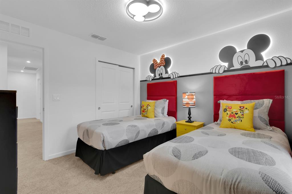 A bedroom features two twin beds with Mickey and Minnie Mouse wall decor — 2312 ZABALLINA PLACE, KISSIMMEE, FL