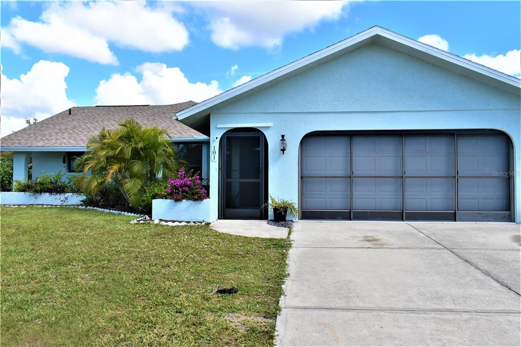 A light blue single-story house features a front entrance, a garage, and a palm tree — 181 BUNKER ROAD, ROTONDA WEST, FL