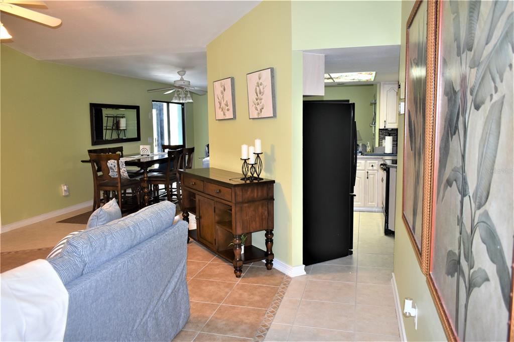 A view of a living room, dining area, and kitchen with light green walls — 181 BUNKER ROAD, ROTONDA WEST, FL