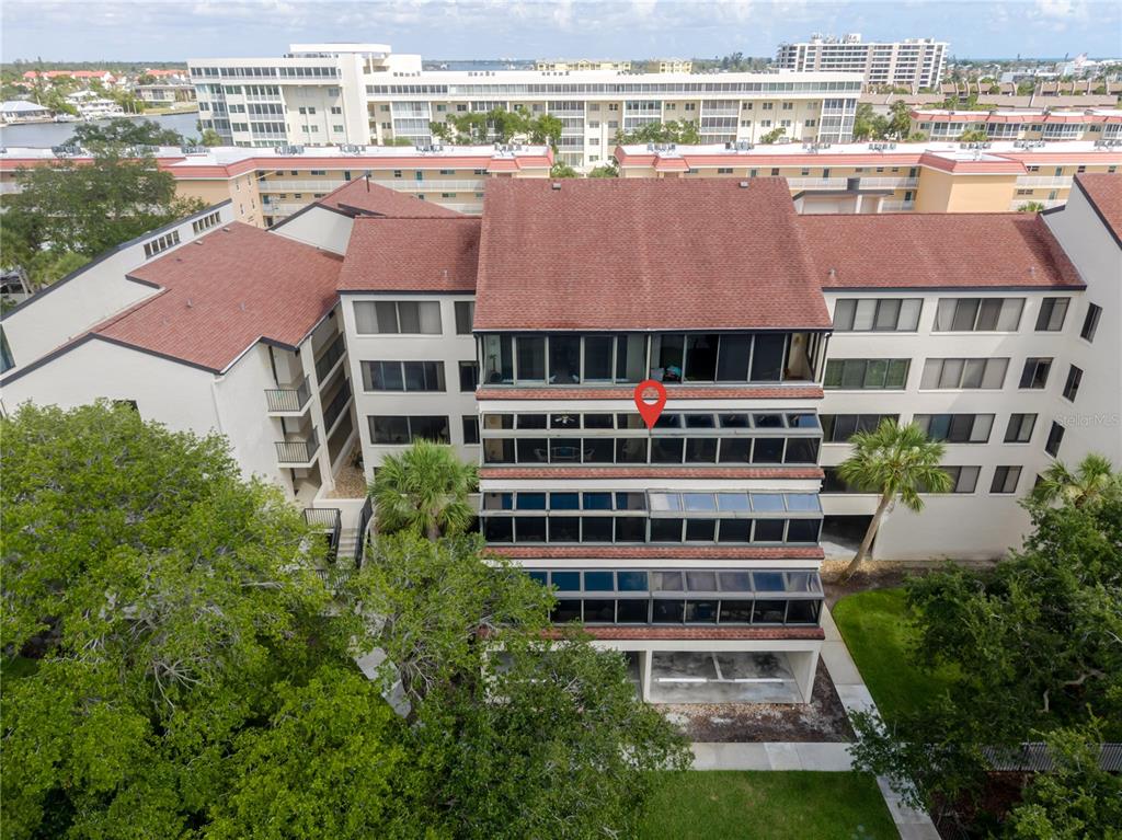 An aerial view shows the exterior of a multi-story apartment building with a red pin — 6267 MIDNIGHT PASS ROAD UNIT 306, SARASOTA, FL